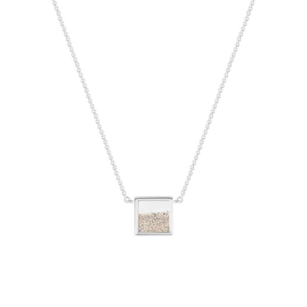 A square silver pendant with silver chain with a free flowing mix of sand behind sapphire glass from front.