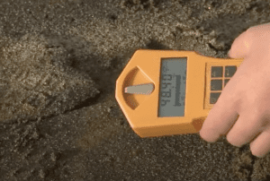 Sand and a monitor showing high radioactive levels